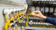 Electricians hands testing current  electric in control panel.